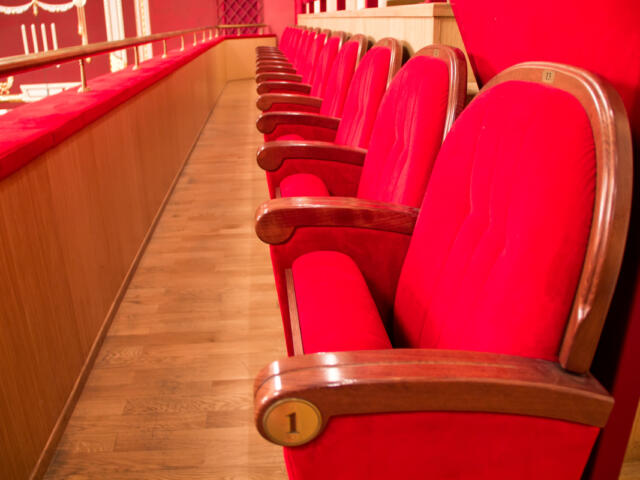 A row of red seats in a theater.