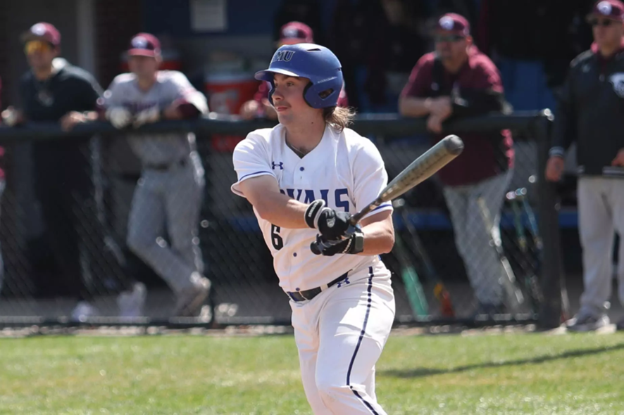 An Eastern Mennonite University baseball player swings the bat.
