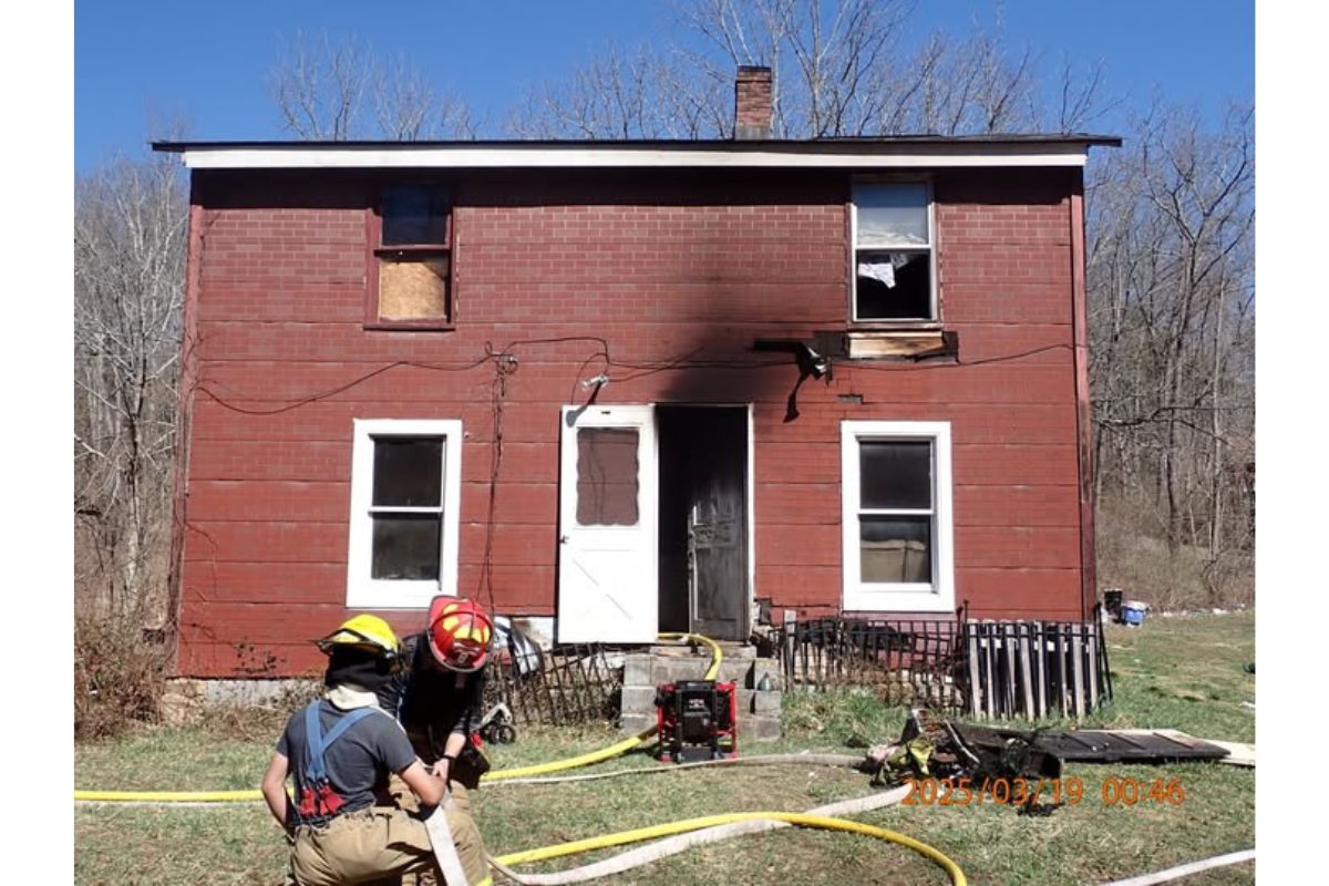 A red brick house with smoke damage to the outside.