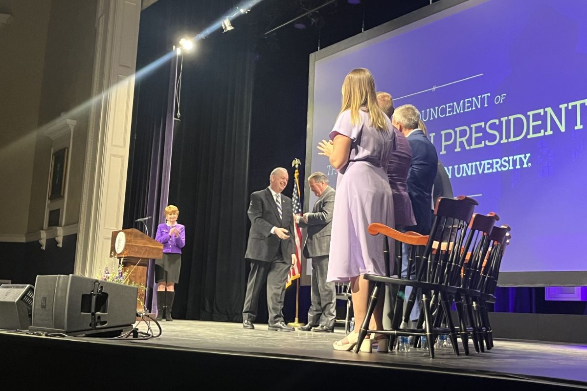 Dr. James C. Schmidt gets sworn in on stage with several James Madison University officials.