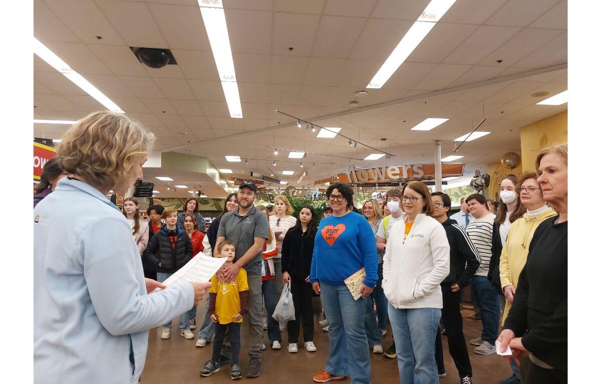 Several participants stand in a group to hear instructions and rules for the event.