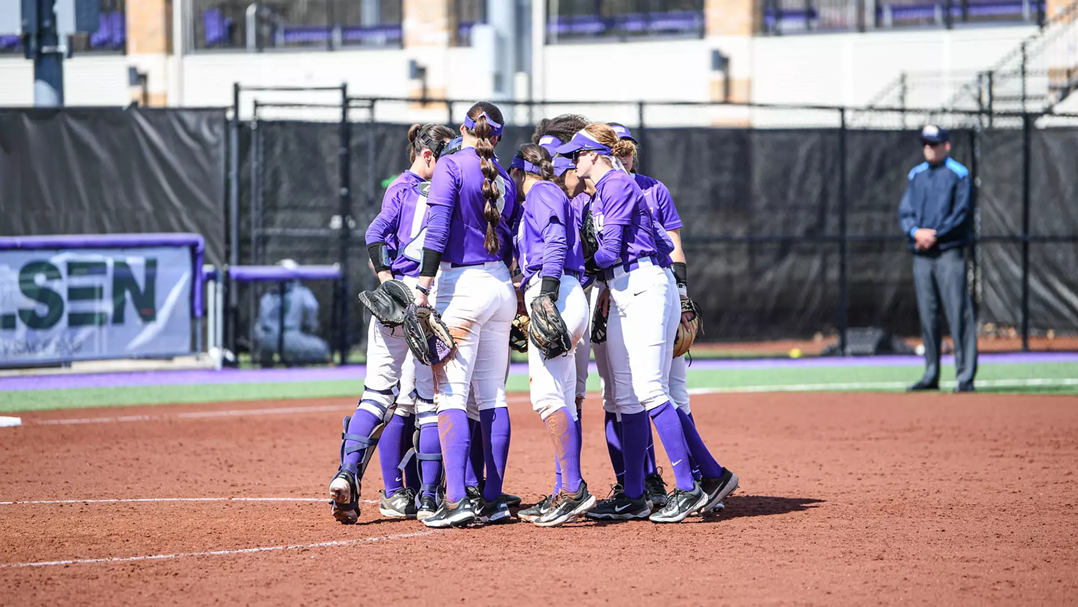 James Madison University softball players huddle in a circle.