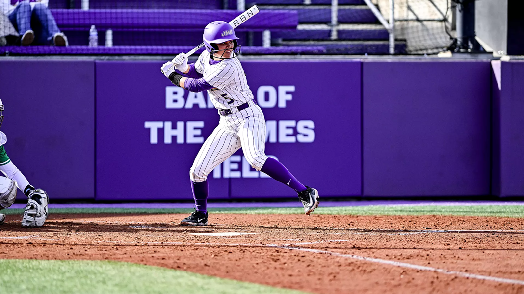A James Madison University softball player gets ready to hit the ball.