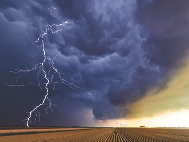 Clouds with a lightning strike in a field