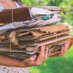 A person holding a stack of cardboard.