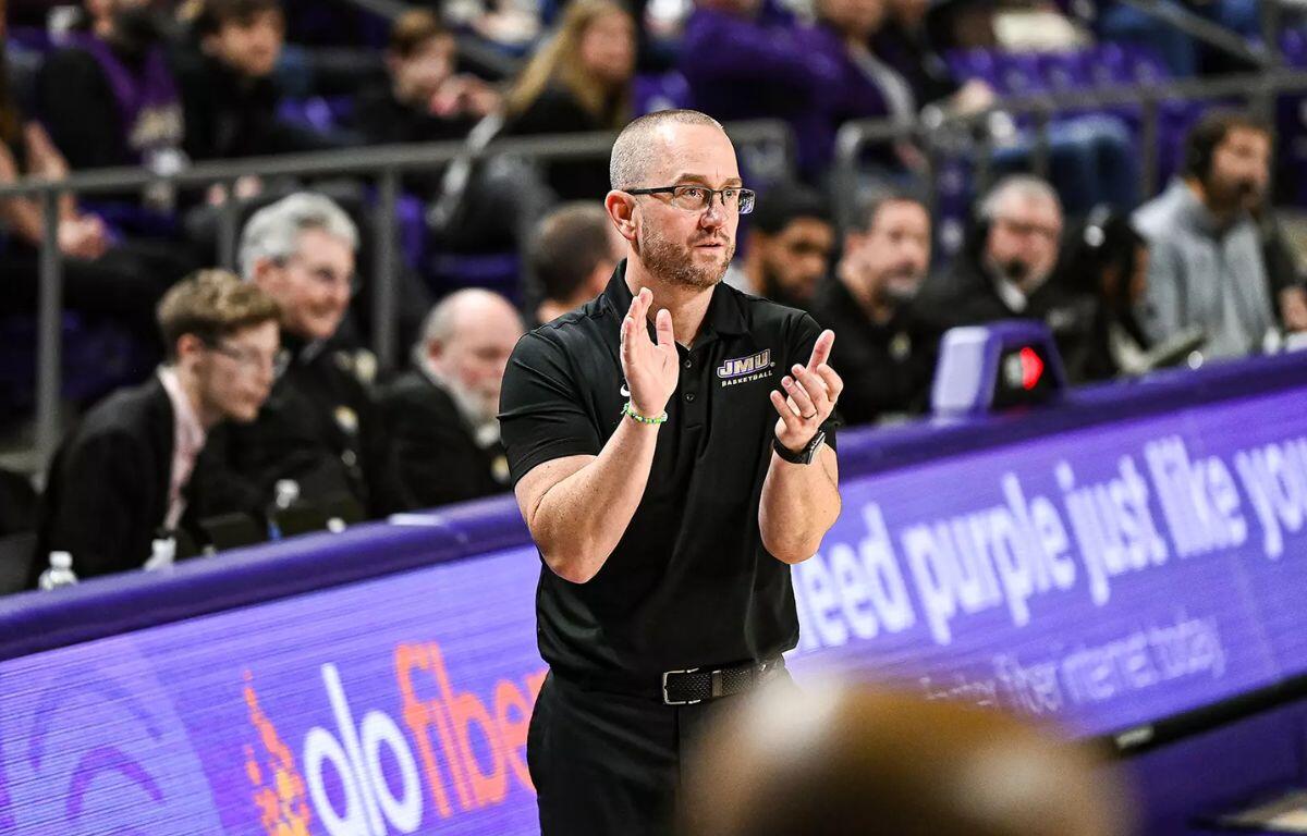 Head coach Sean O'Regan claps hands courtside.