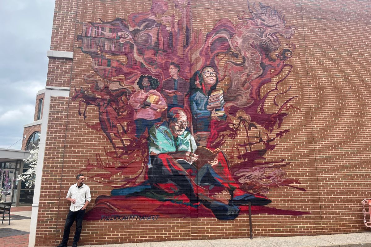 Tyler Kauffman in front of the Massanutten Regional Library Mural