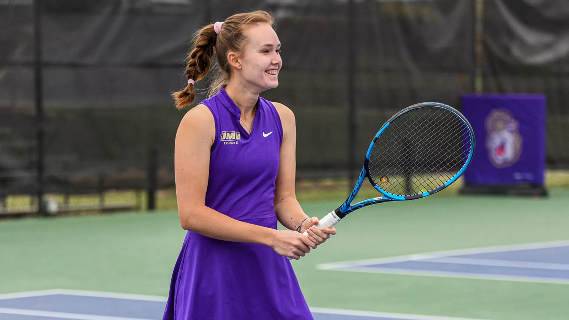 James Madison junior Daria Munteanu holding a tennis racket