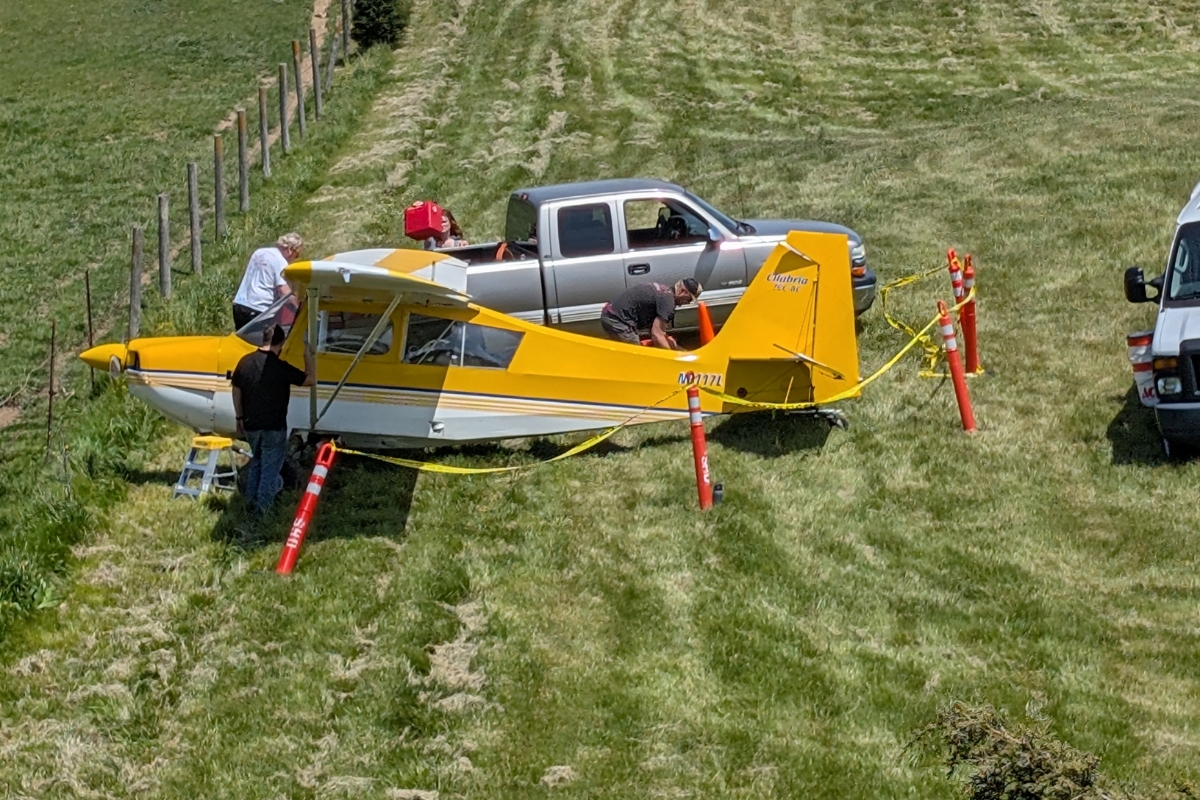 A small yellow plane in a grass field.