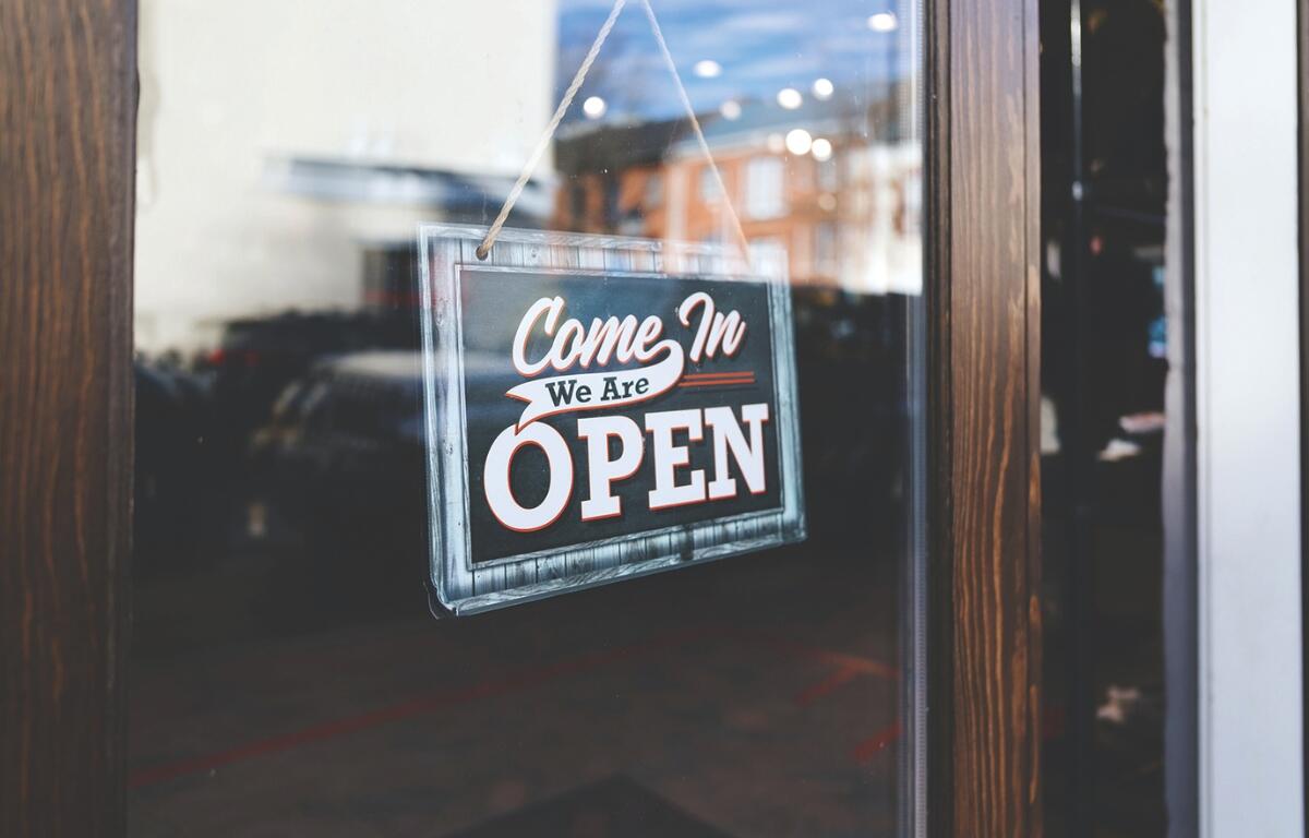 A close up of an open sign on a door.
