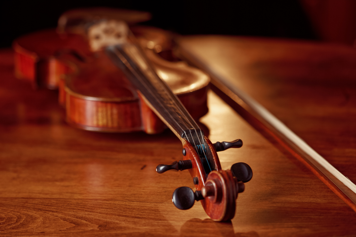 Violin in retro style on wooden table, closeup