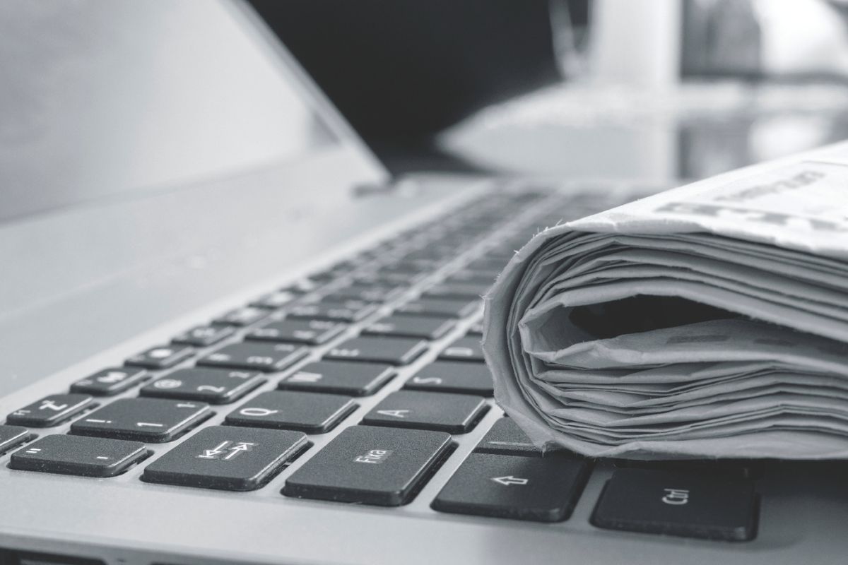 Laptop with rolled up newspaper on top of keyboard