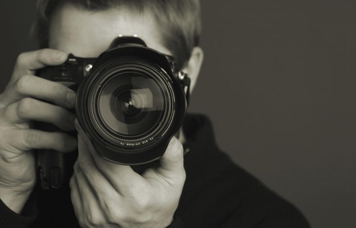 A person taking a photo with a professional camera.