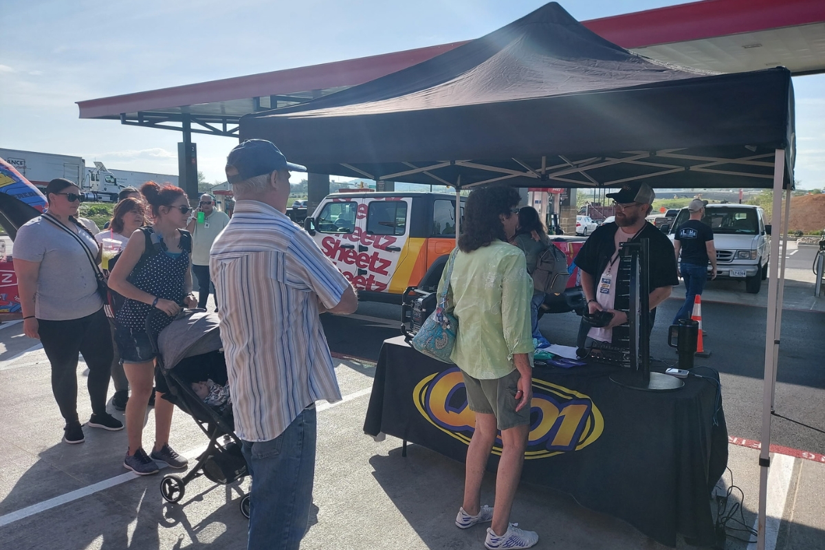 The Q101 radio tent and table set up with on-air personality Riley Reed talking with Sheetz customers.
