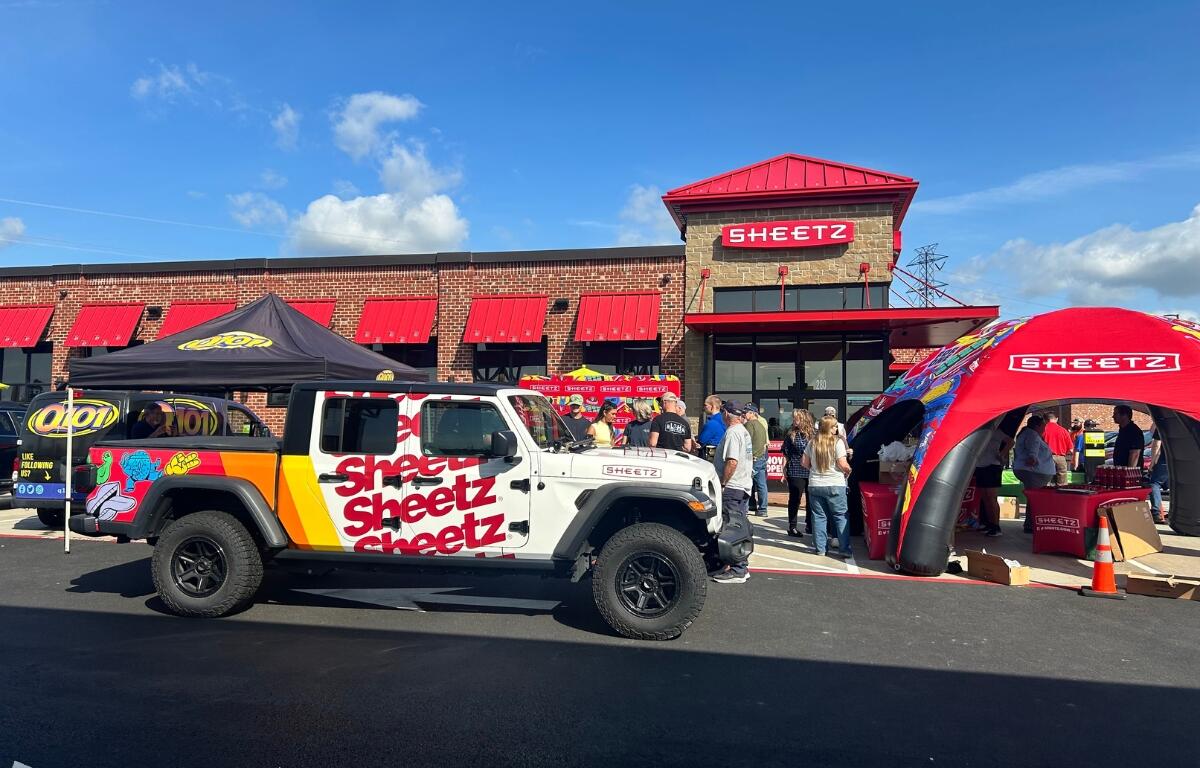 A Sheetz wrapped Jeep truck in front of the new Sheetz building in Mount Crawford with a crowd.