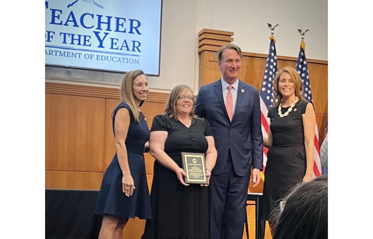 Karen Grady receives a plaque from Governor Glenn Youngkin and staff.