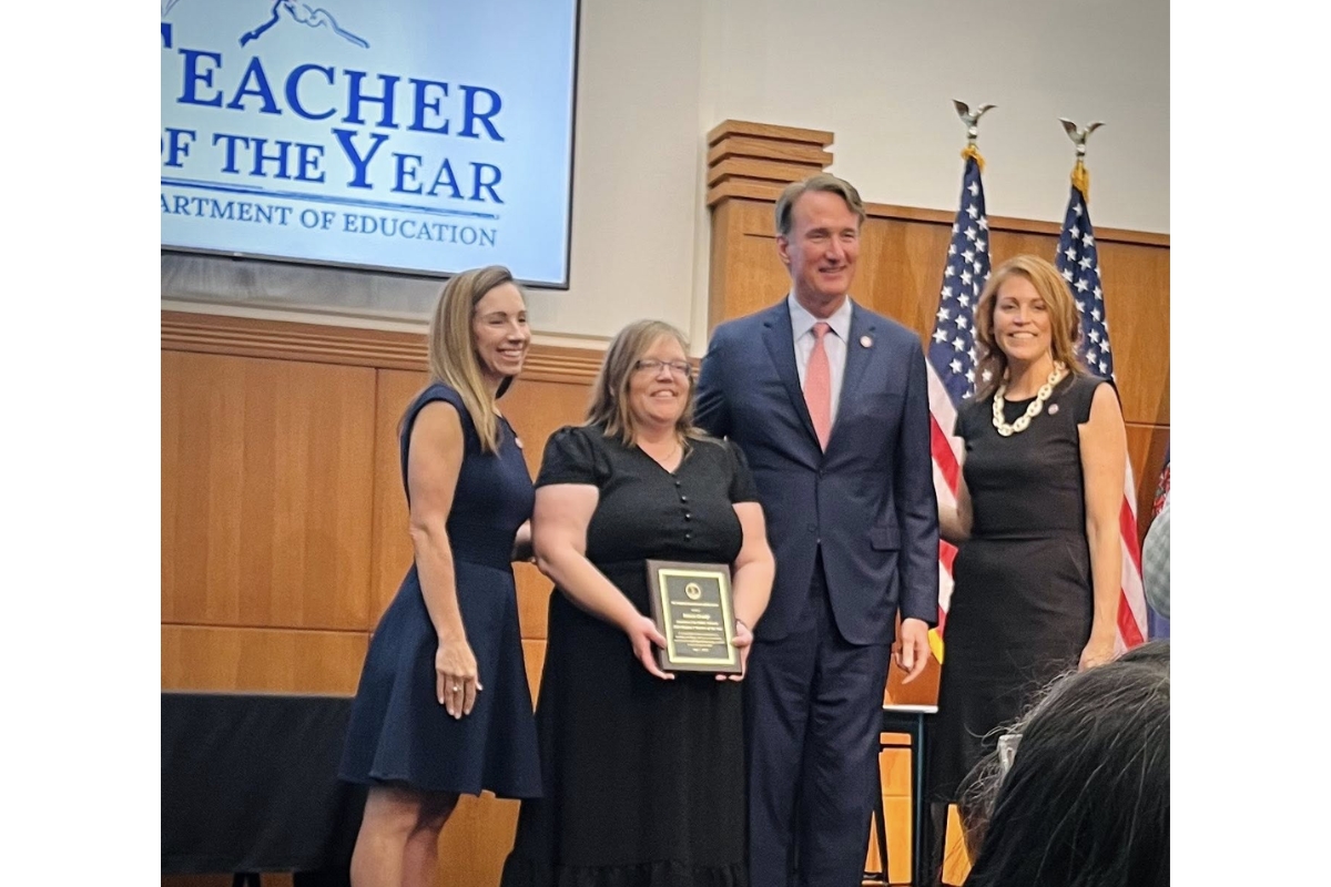 Karen Grady receives a plaque from Governor Glenn Youngkin and staff.