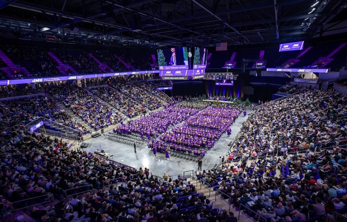 An overview of the inside of the Atlantic Union Bank Center with grads sitting on chairs on the floor and the stands full of people.