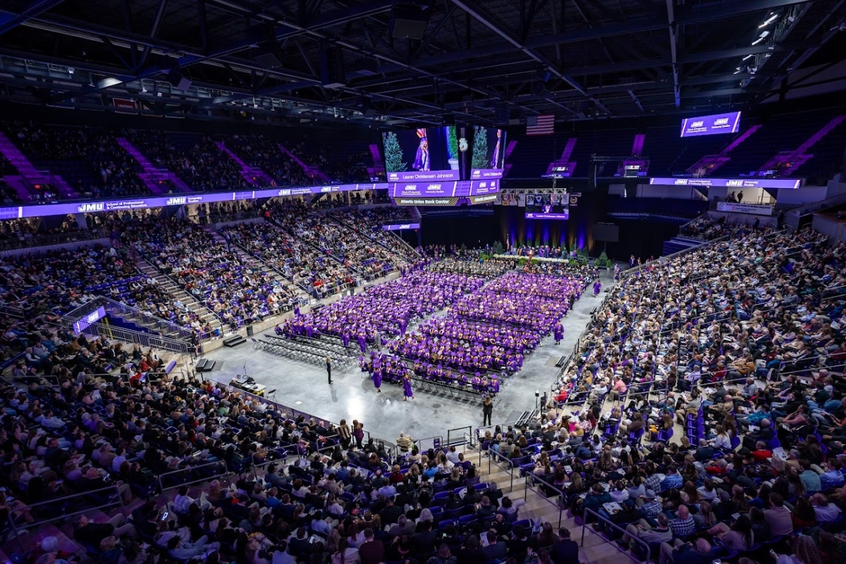An overview of the inside of the Atlantic Union Bank Center with grads sitting on chairs on the floor and the stands full of people.