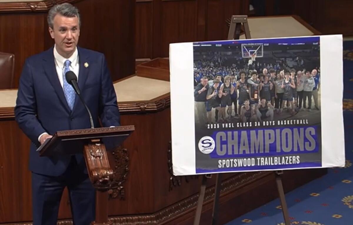 Ben Cline on the House floor with a poster of the Spotswood Boys Basketball team.