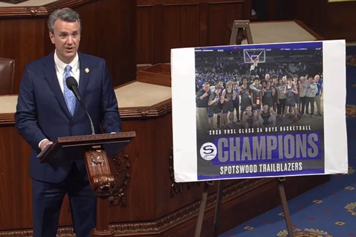 Ben Cline on the House floor with a poster of the Spotswood Boys Basketball team.