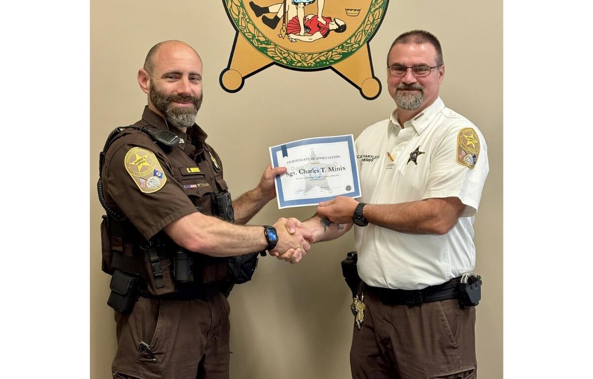 Sheriff Chris Hartless presents a recognition to Staunton City police Sergeant Charles Minix.