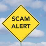 Scam Alert on yellow sign with clouds in the background