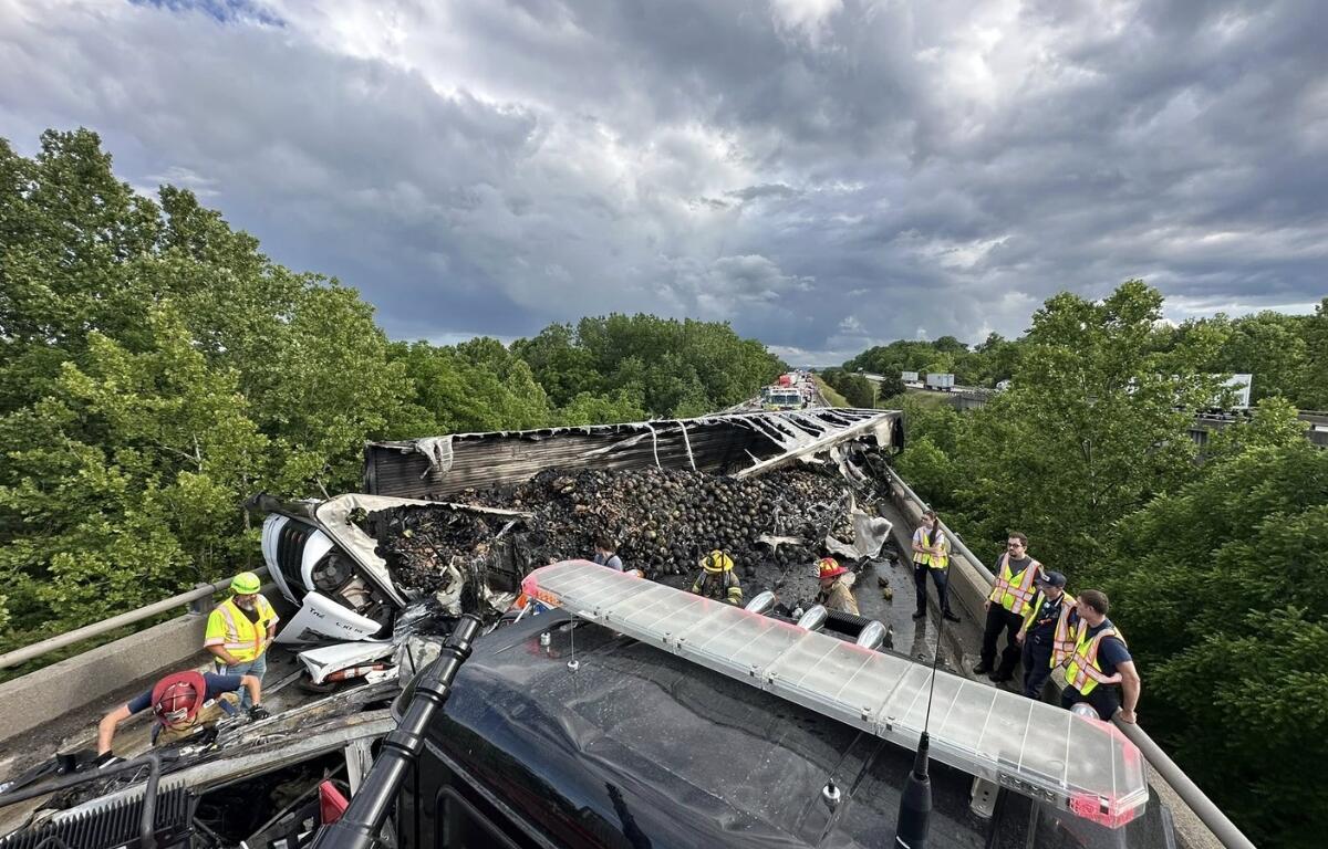 An overturned tractor trailer with burnt insides.