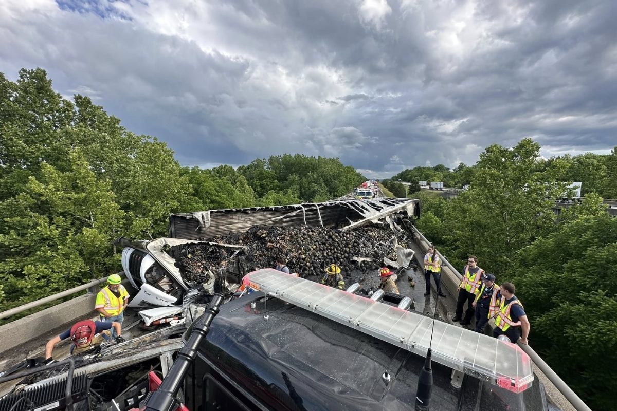 An overturned tractor trailer with burnt insides.