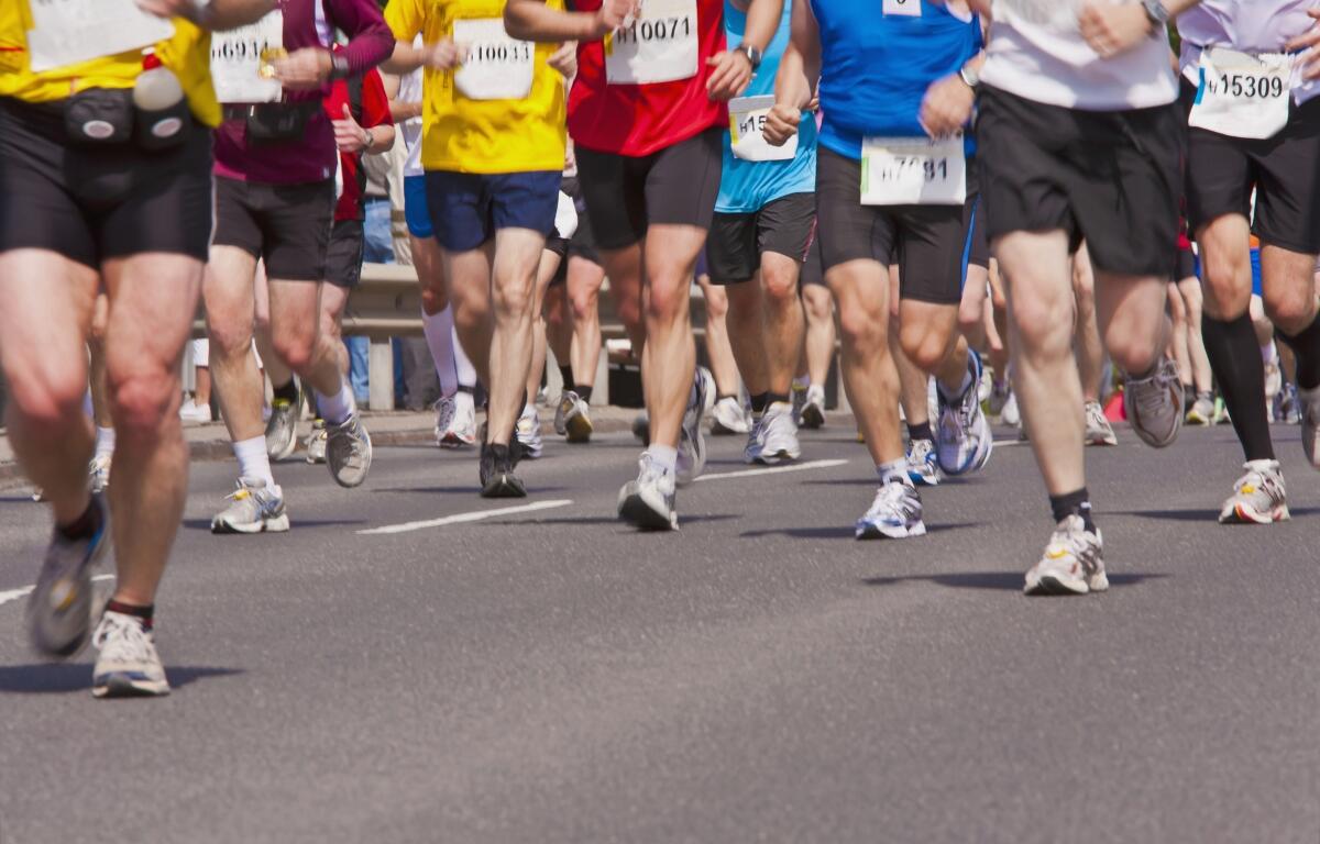 Multiple people running on pavement for a marathon race.
