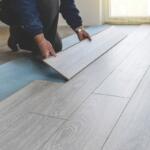 A person laying hardwood flooring.