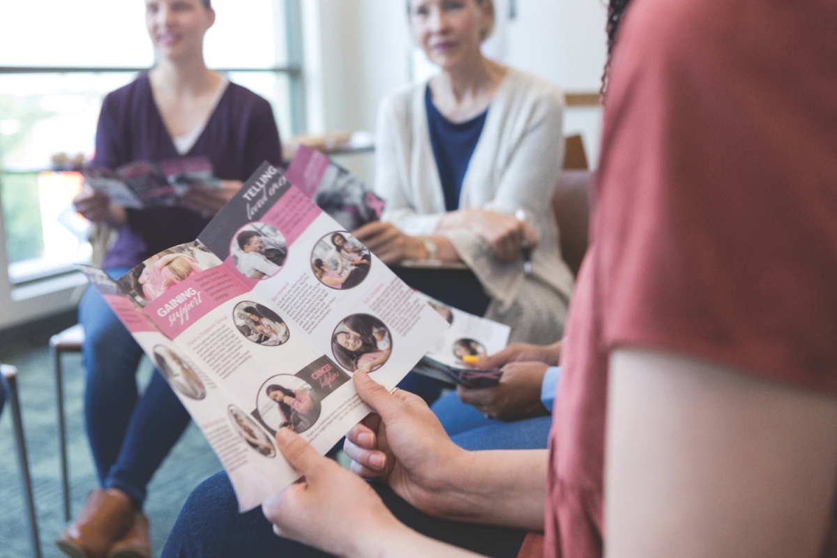 A woman looking at a health pamphlet.