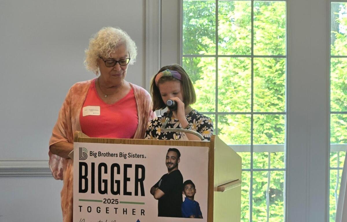 Josie Crapenzano and her daughter speak at a podium.