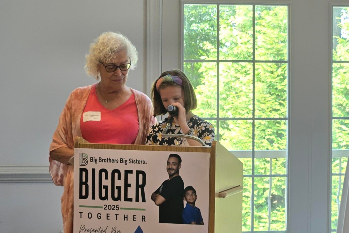 Josie Crapenzano and her daughter speak at a podium.
