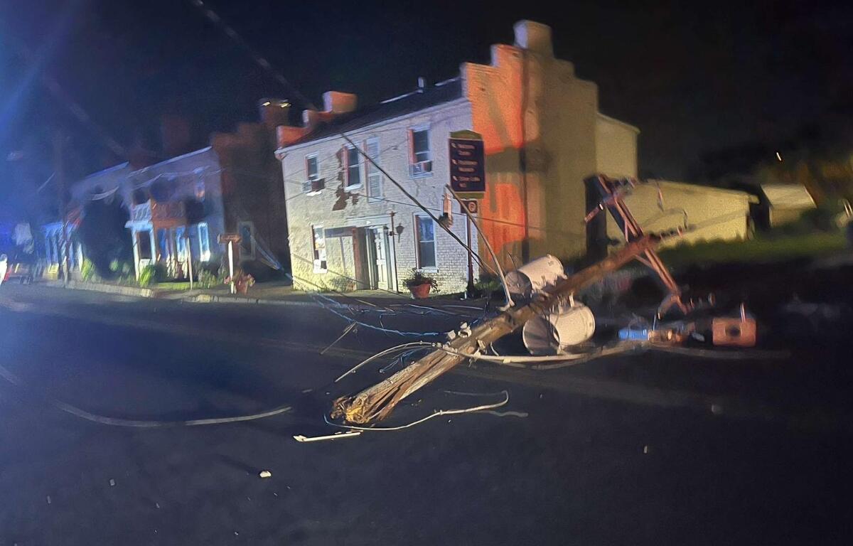 Half of a power pole laying on a road.