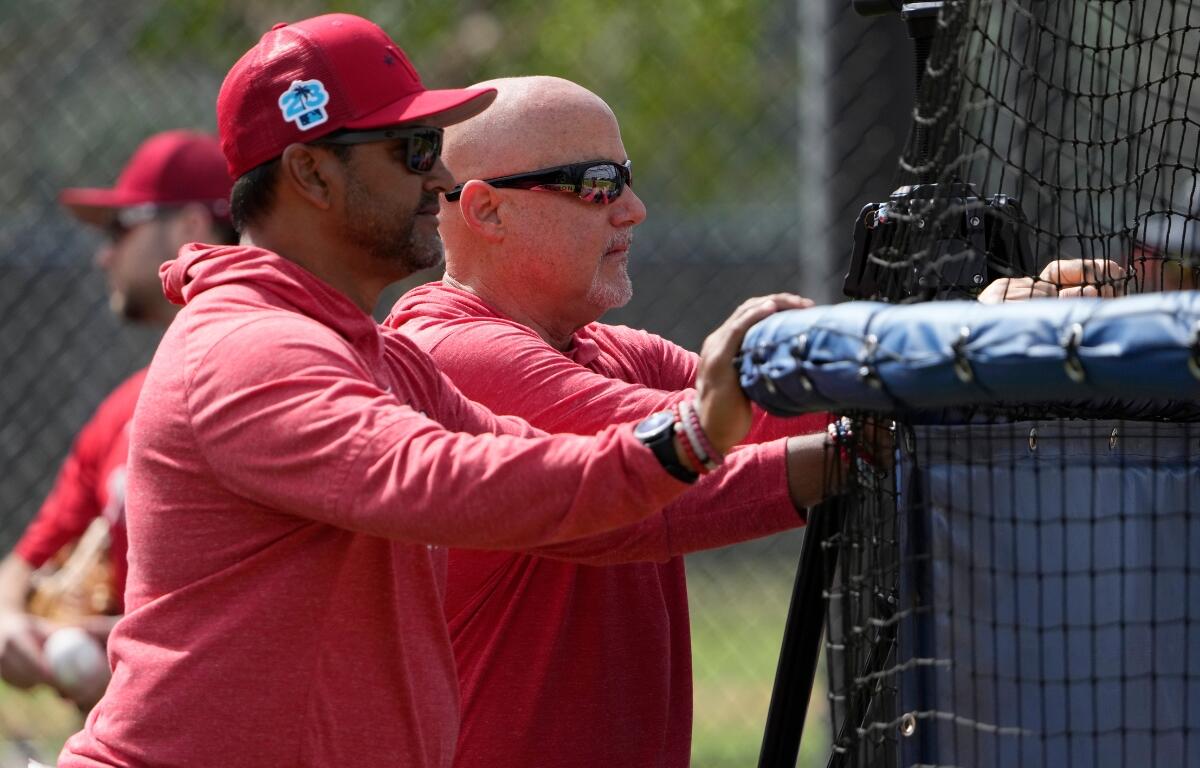 Washington Nationals manager Dave Martinez, left, watches with general manager Mike Rizzo during spring training baseball practice Saturday, Feb. 18, 2023, in West Palm Beach, Fla.