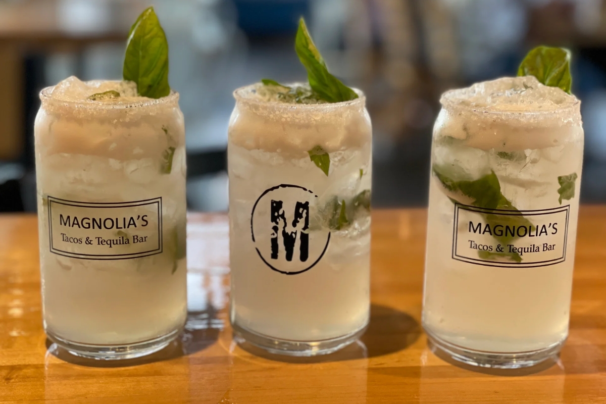 Three margaritas on a wooden table.
