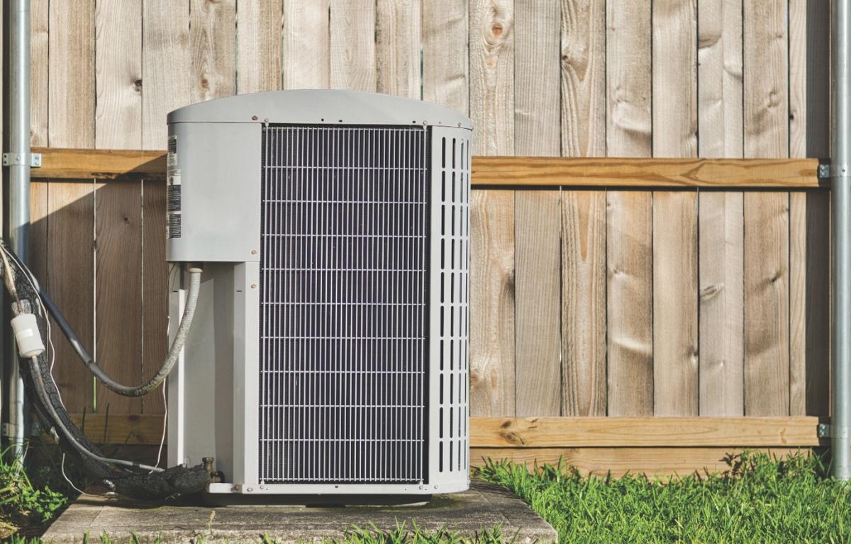 An air conditioner unit near grass.