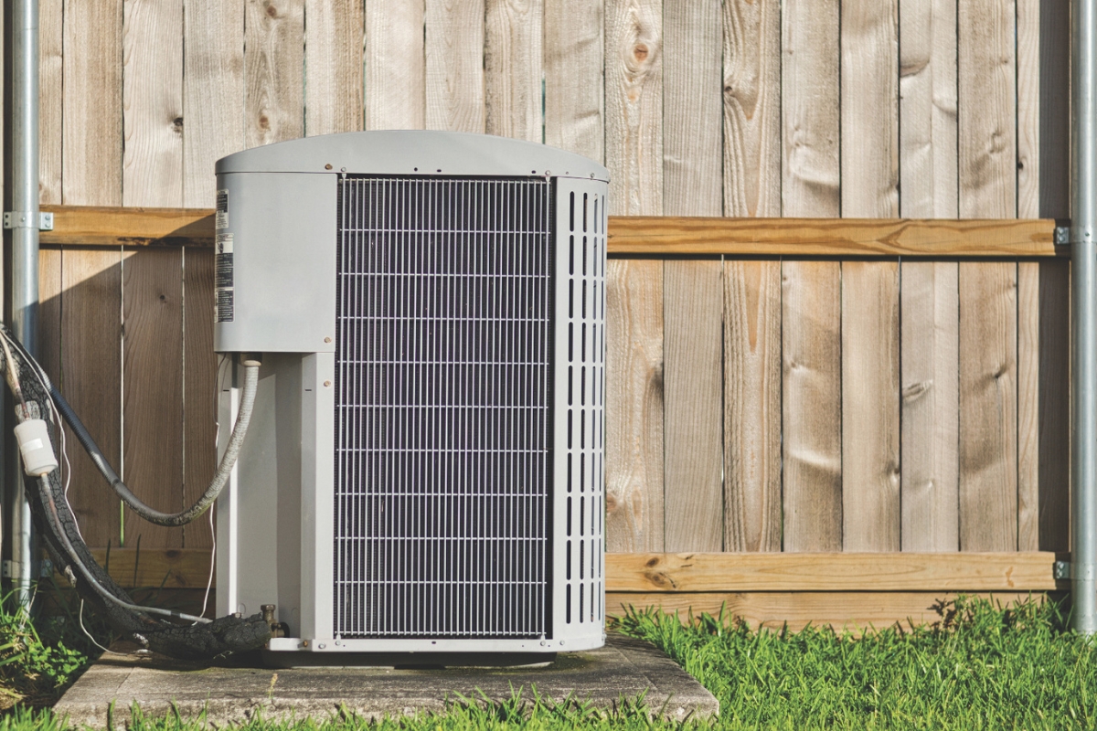 An air conditioner unit near grass.