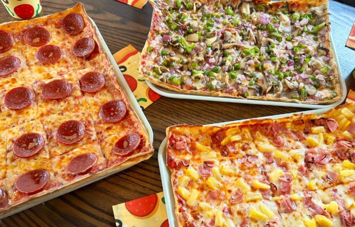 A pepperoni pizza, a Hawaiian pizza, and a veggie pizza.