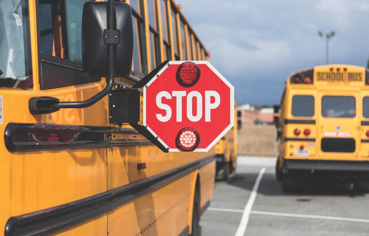 Up close of a school bus with the stop sign extended.