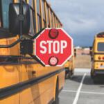 Up close of a school bus with the stop sign extended.