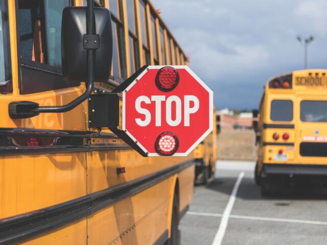 Up close of a school bus with the stop sign extended.