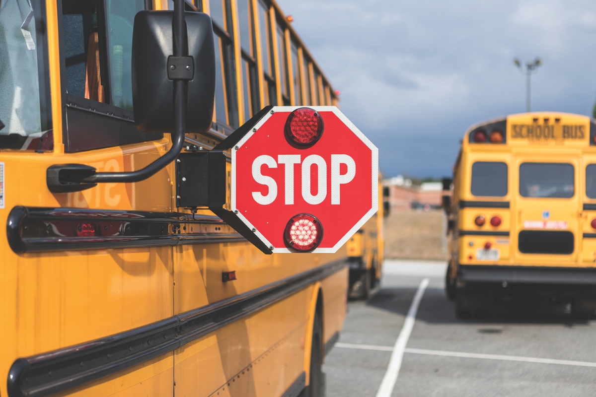 Up close of a school bus with the stop sign extended.