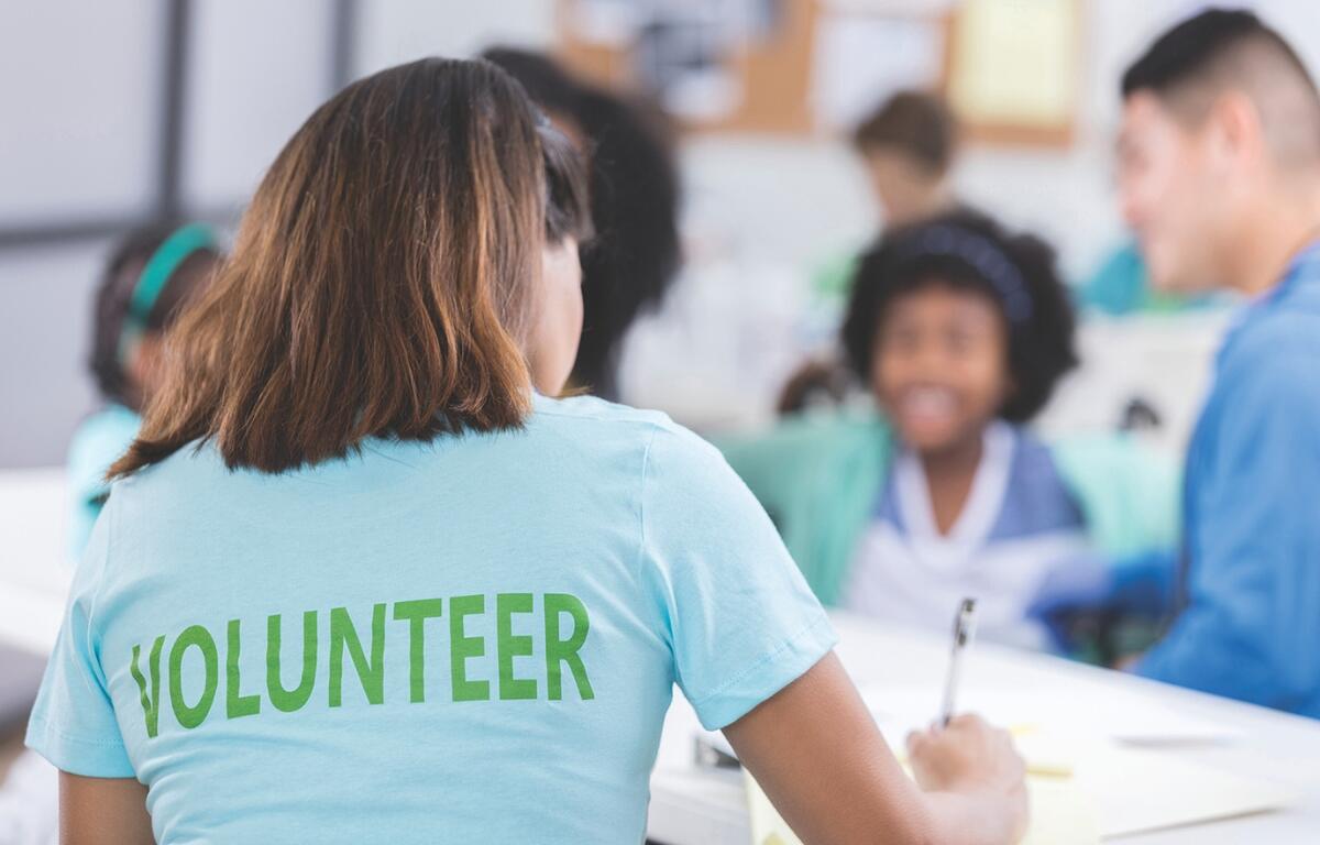 A volunteer signing people in at a table.