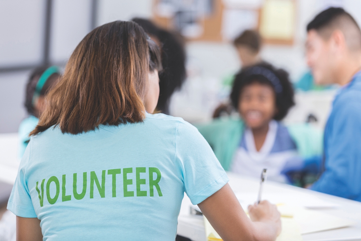 A volunteer signing people in at a table.