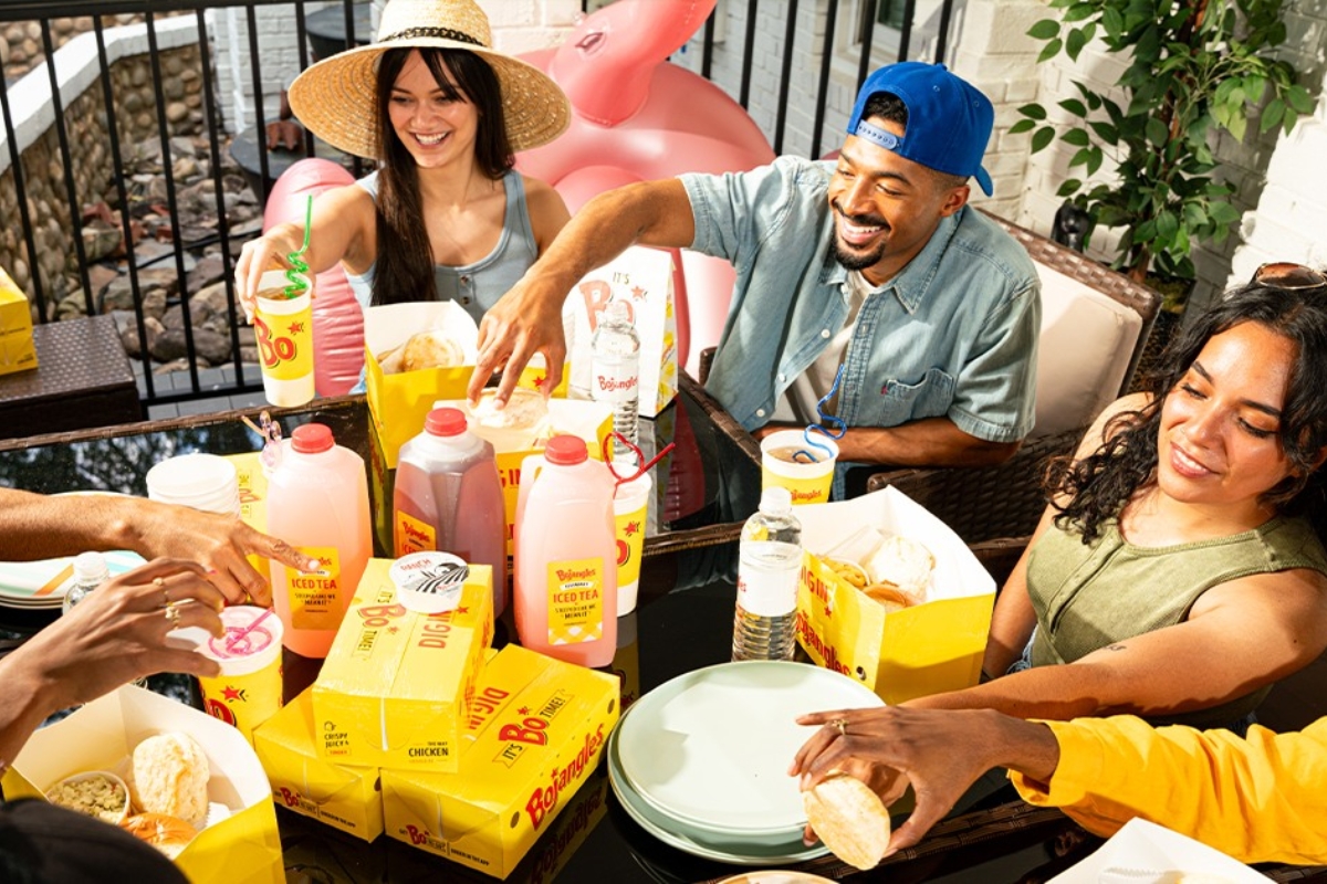 A group of people at a table with Bojangles food and drinks.