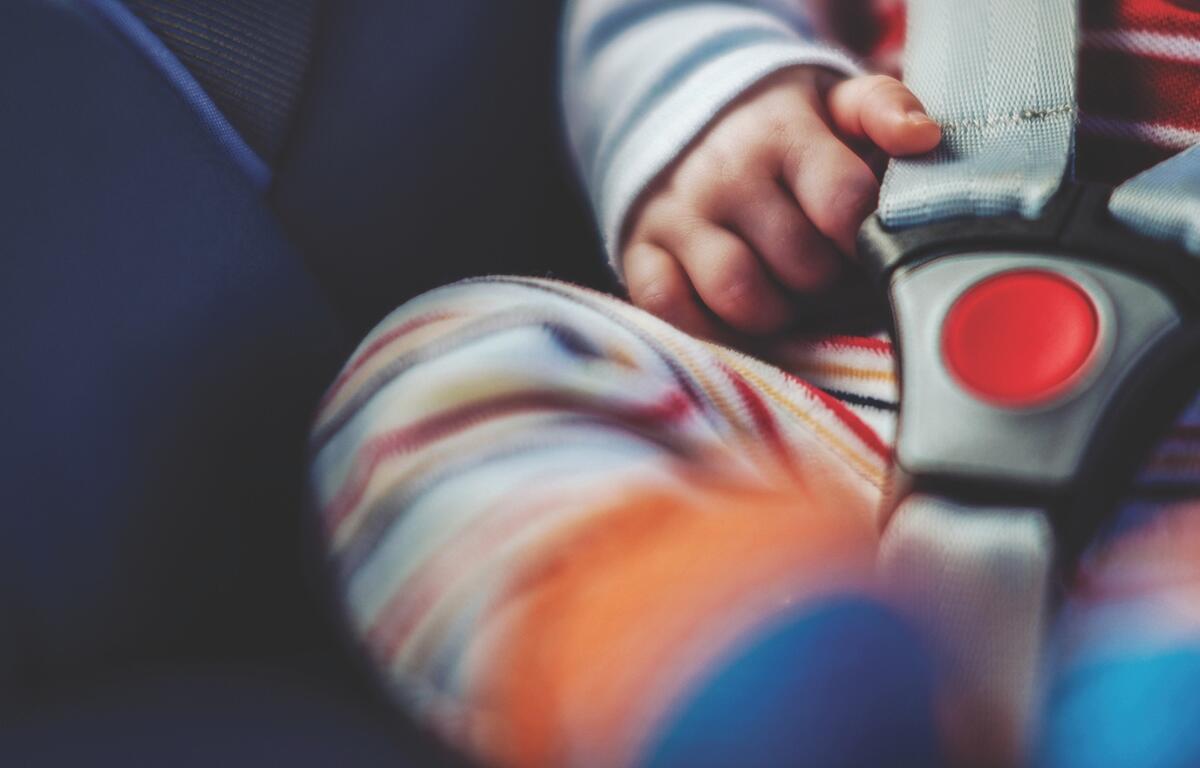 Up close of a baby in a buckled car seat