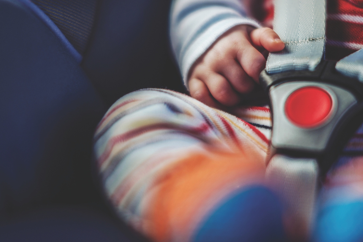Up close of a baby in a buckled car seat