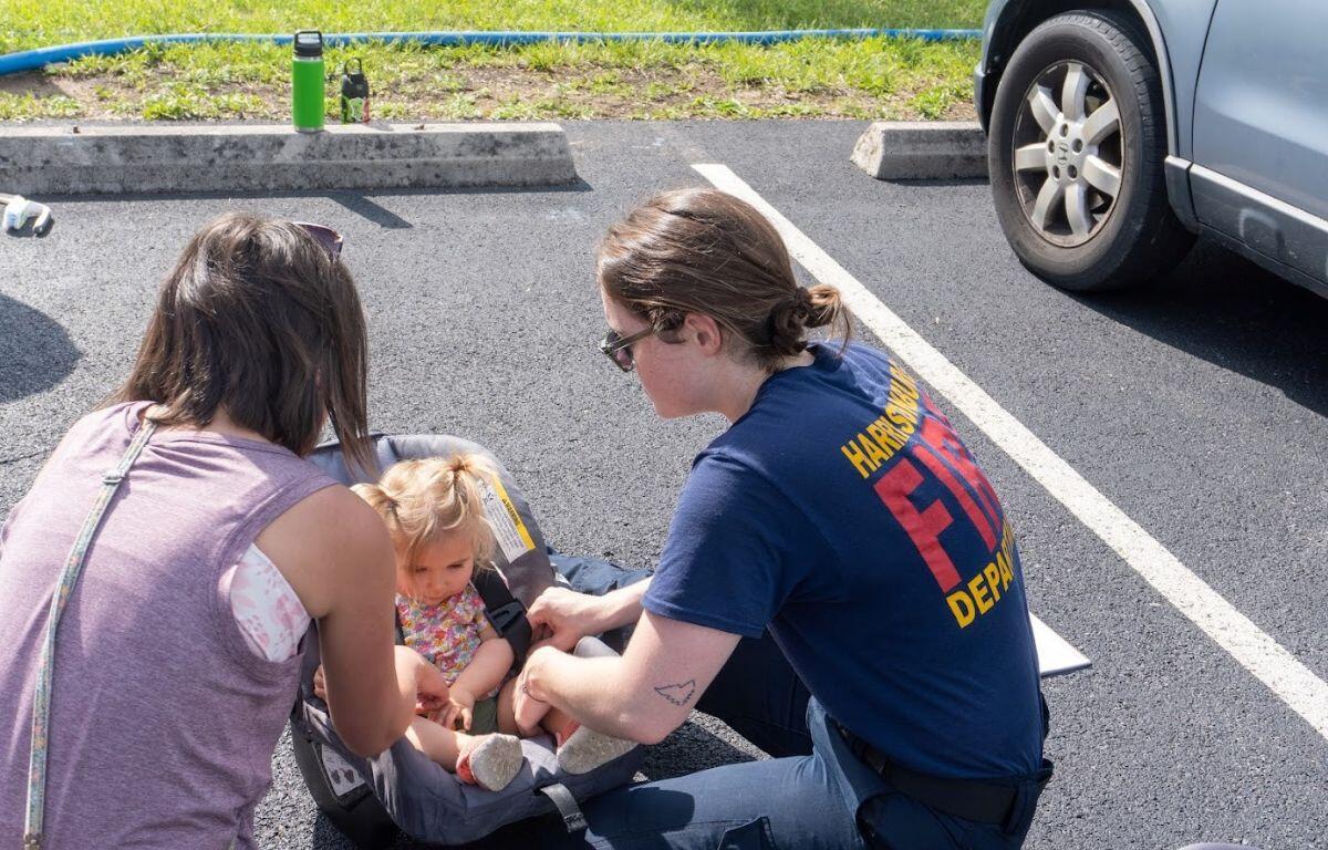 HFD member Leslie Pullen assists a community member with a car seat safety check. A recent VDH grant will support HFD's efforts to conduct more child safety activities in Harrisonburg